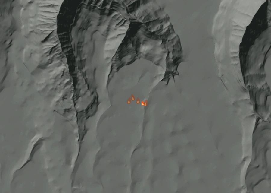 Shaded relief map of the Apple Fire. Amber flames mark every place that gave off heat in the last day; the shading is the shape of the ground.
