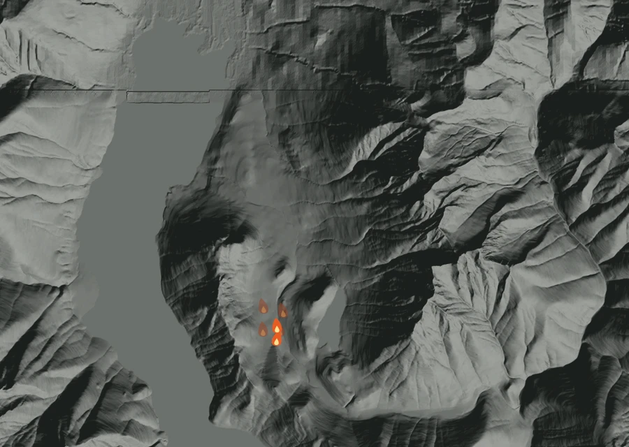 Shaded relief map of the Border 2 Fire. Amber flames mark every place that gave off heat in the last day; the shading is the shape of the ground.