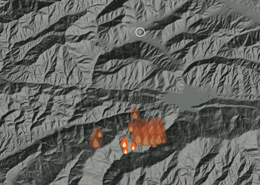 Shaded relief map of the Bouquet Fire. Amber flames mark every place that gave off heat in the last day; the shading is the shape of the ground.