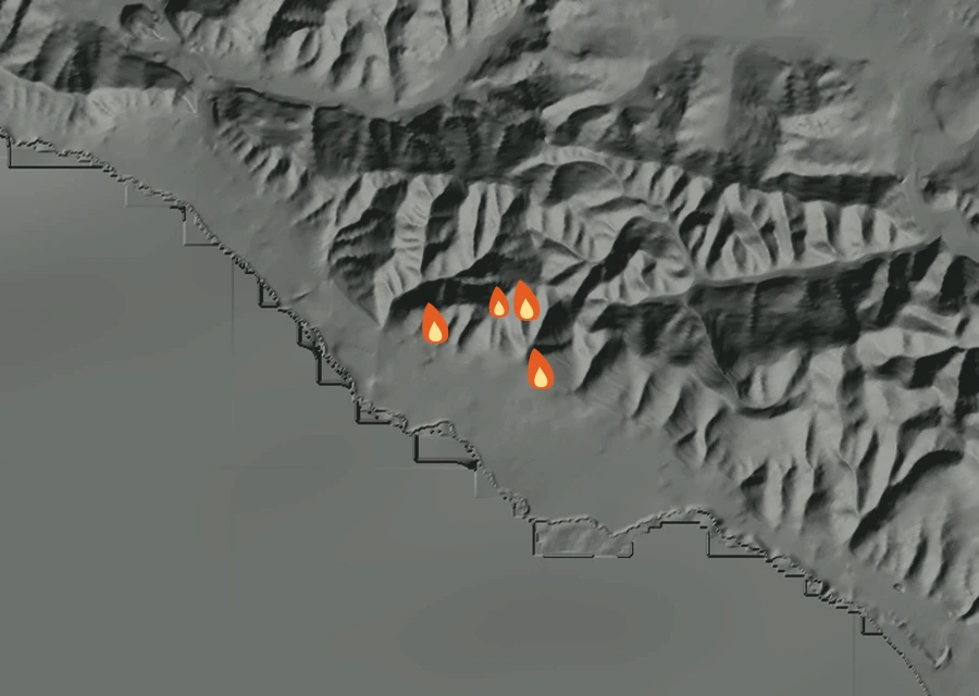 Shaded relief map of the Brava Fire. Amber flames mark every place that gave off heat in the last day; the shading is the shape of the ground.
