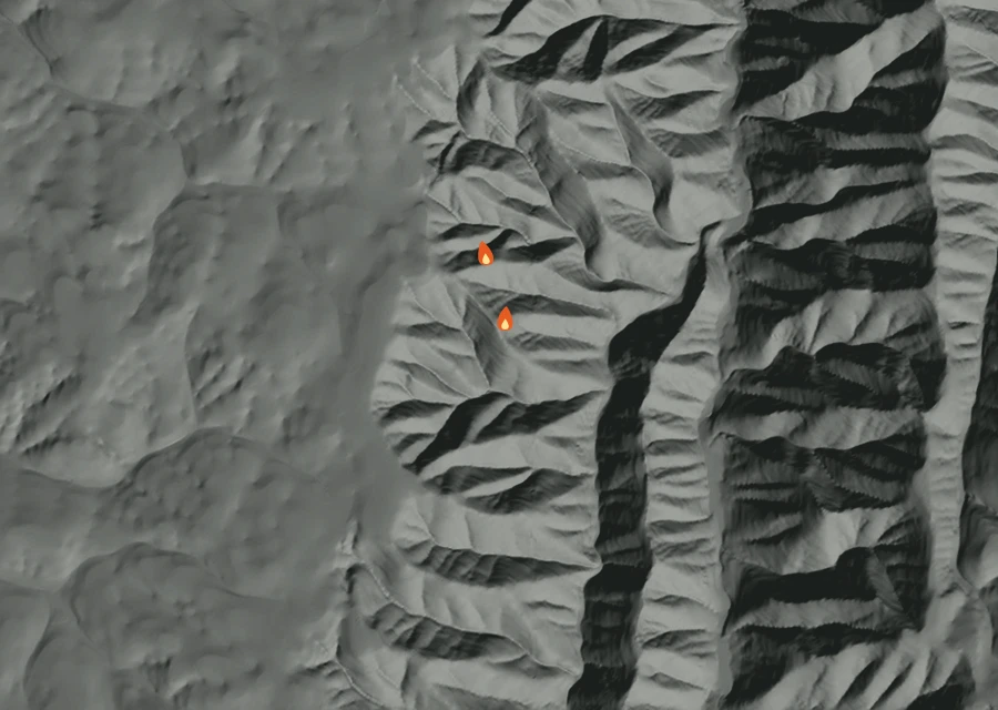 Shaded relief map of the Burnt Creek Fire. Amber flames mark every place that gave off heat in the last day; the shading is the shape of the ground.