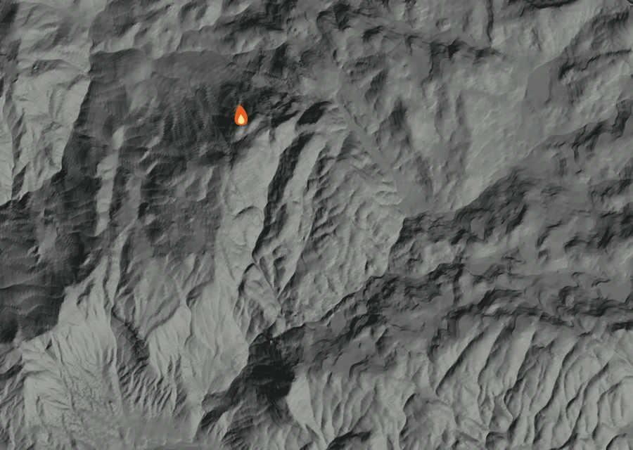 Shaded relief map of the Dome Fire. Amber flames mark every place that gave off heat in the last day; the shading is the shape of the ground.