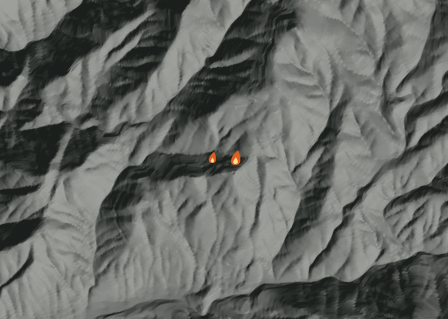 Shaded relief map of the Flat Fire. Amber flames mark every place that gave off heat in the last day; the shading is the shape of the ground.