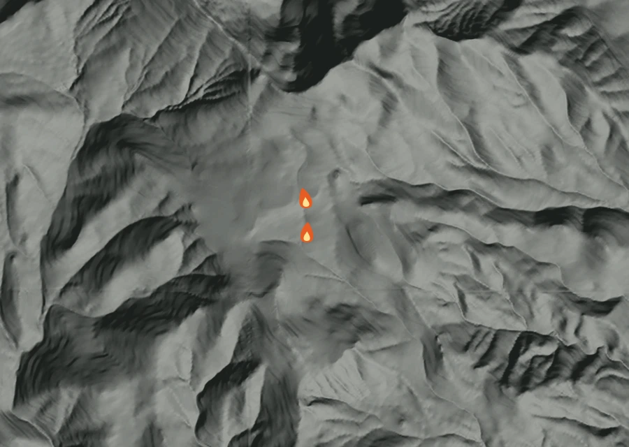 Shaded relief map of the Inc 686 Fire. Amber flames mark every place that gave off heat in the last day; the shading is the shape of the ground.