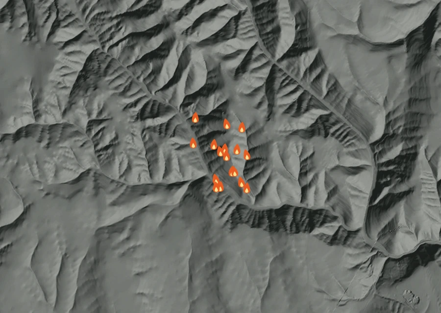 Shaded relief map of the Middle Ridge Fire. Amber flames mark every place that gave off heat in the last day; the shading is the shape of the ground.