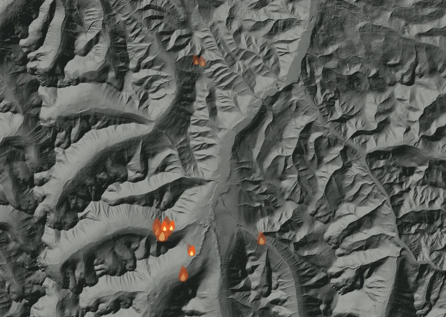Shaded relief map of the Ptarmigan Fire. Amber flames mark every place that gave off heat in the last day; the shading is the shape of the ground.