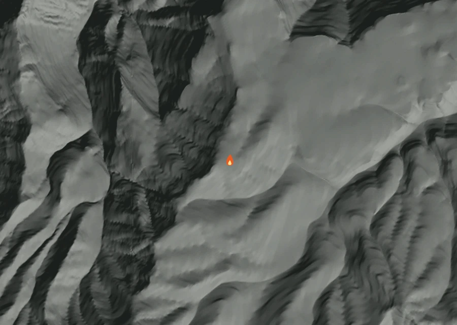 Shaded relief map of the Rand Creek Fire. Amber flames mark every place that gave off heat in the last day; the shading is the shape of the ground.