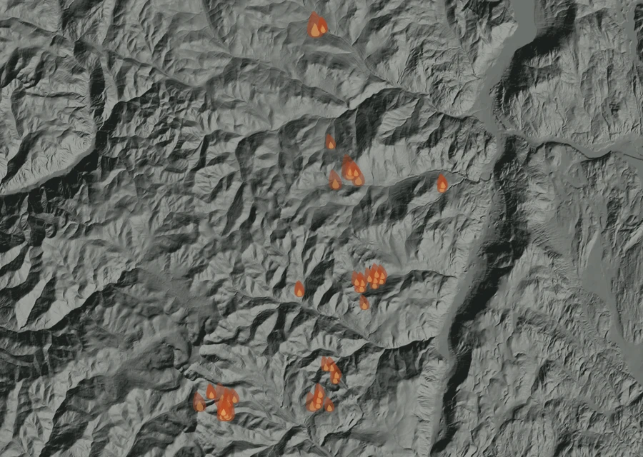 Shaded relief map of the Sinlahekin Fire. Amber flames mark every place that gave off heat in the last day; the shading is the shape of the ground.