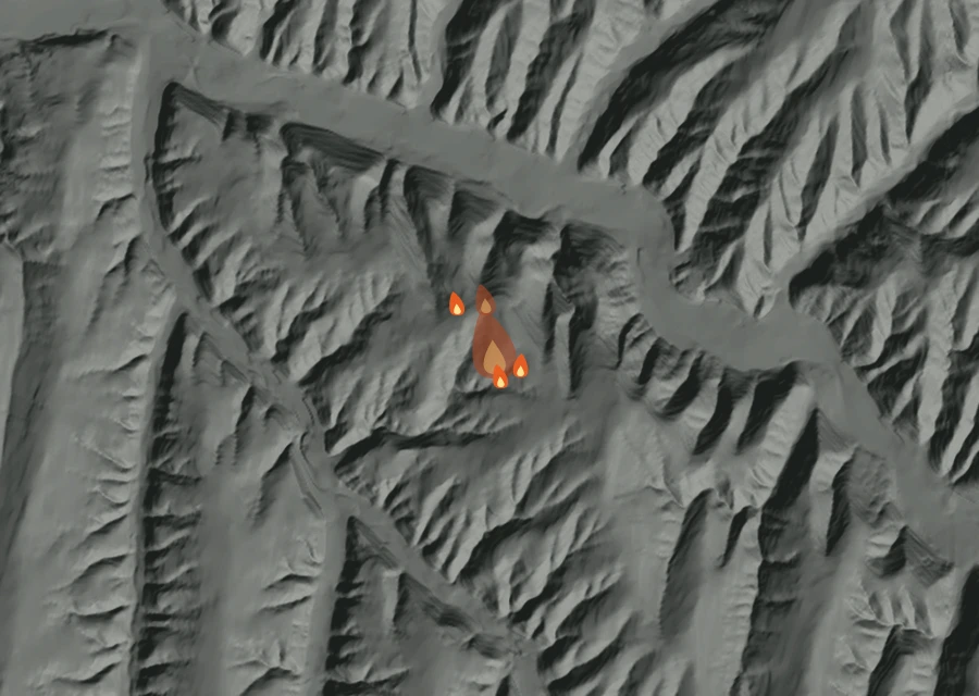 Shaded relief map of the Stewart Fire. Amber flames mark every place that gave off heat in the last day; the shading is the shape of the ground.