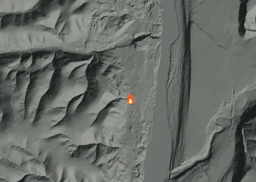 Shaded relief map of the Tarpiscan Fire. Amber flames mark every place that gave off heat in the last day; the shading is the shape of the ground.