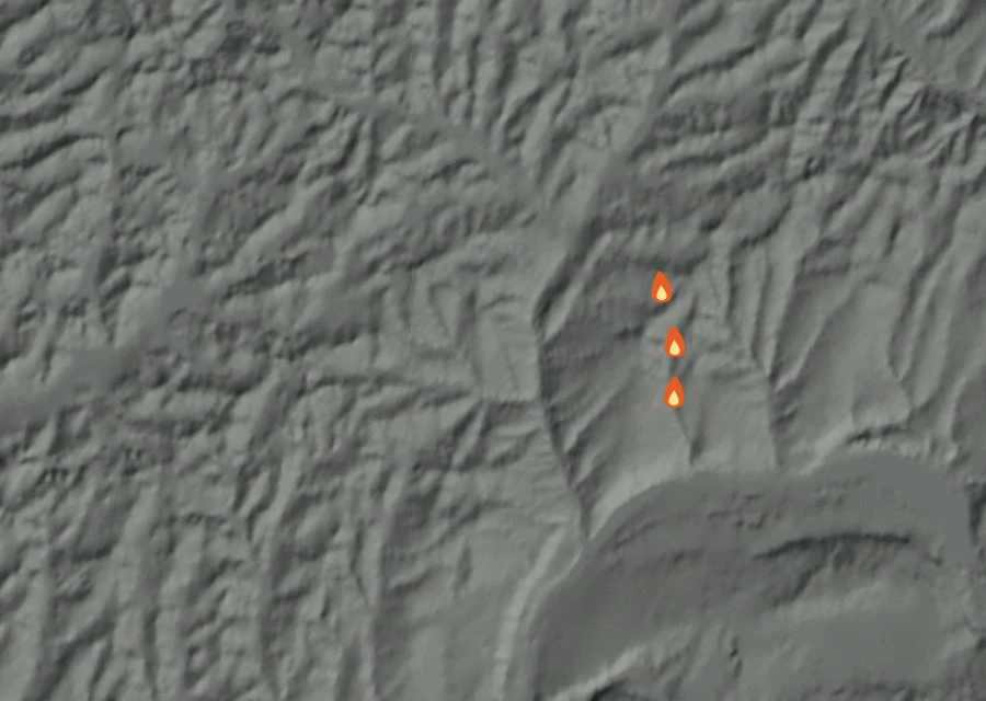 Shaded relief map of the Wells Road Fire. Amber flames mark every place that gave off heat in the last day; the shading is the shape of the ground.