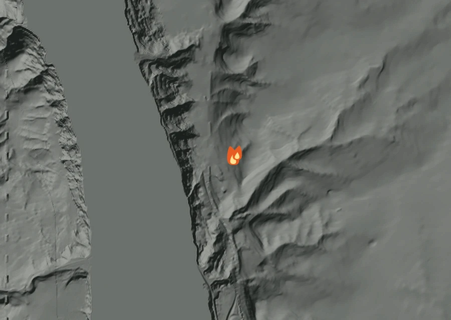 Shaded relief map of the Wildhorse Fire. Amber flames mark every place that gave off heat in the last day; the shading is the shape of the ground.